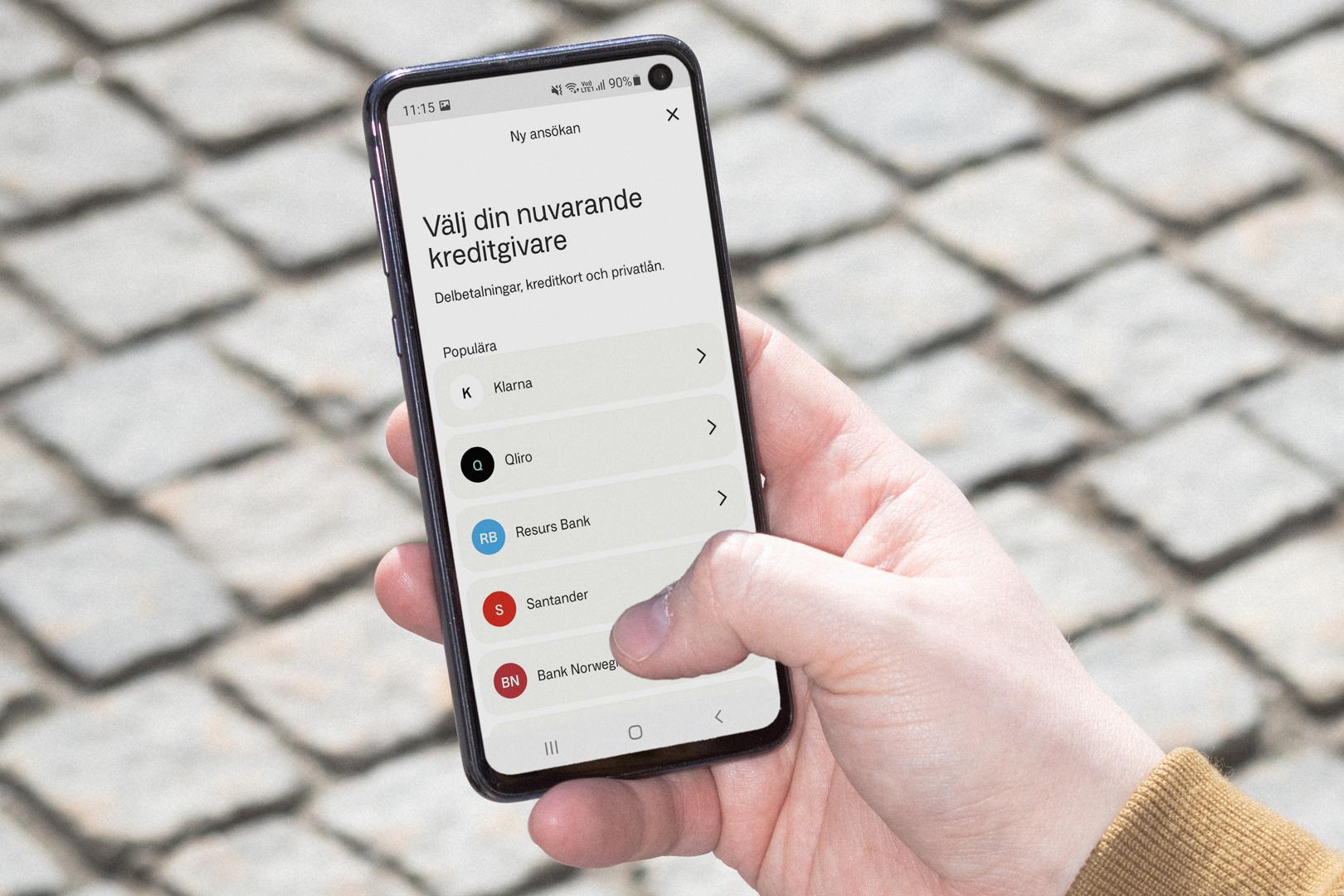 Närbild på två händer som håller i en mobil med Anyfin-appen öppen.