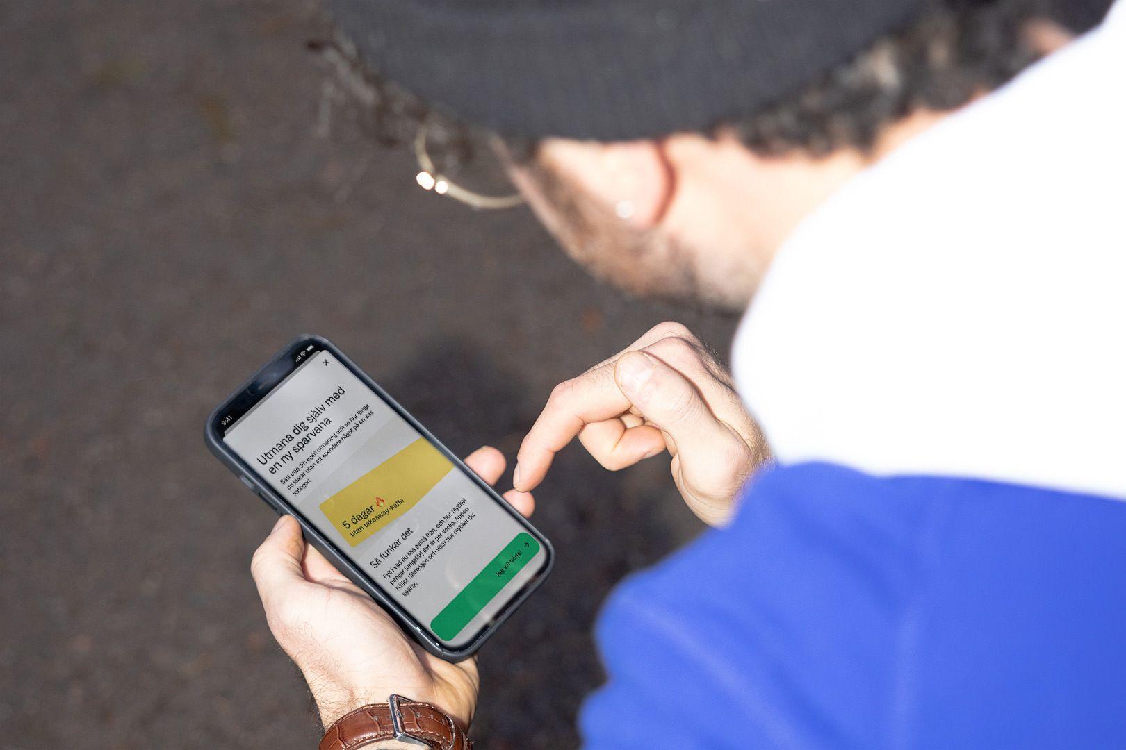 En person håller i en mobiltelefon med Anyfins nya widget. 